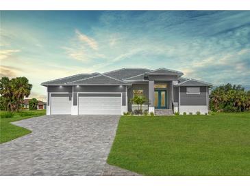 Beautiful new construction home with a three car garage, paver driveway, lush lawn and modern design at 193 Rotonda S Blvd, Rotonda West, FL 33947