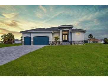 Beautiful single-story home featuring a spacious lawn and a two-car garage at 211 Rotonda S Blvd, Rotonda West, FL 33947