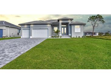 Beautiful gray home with well manicured lawn and paver driveway, offering great curb appeal at 221 Rotonda S Blvd, Rotonda West, FL 33947