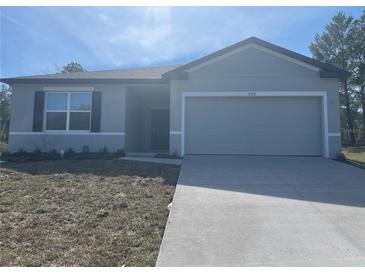 Charming single-Gathering home showcasing a well-manicured lawn and a two-car garage at 11330 Godwit Ave, Weeki Wachee, FL 34613