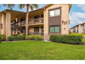 Inviting condo building with manicured lawn and lush landscaping in a well-maintained community at 721 83Rd N Ave # 108, St Petersburg, FL 33702