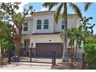 Stunning two-story home with a gated entrance, beautiful landscaping, and tile roof at 1966 Hyde Park St, Sarasota, FL 34239