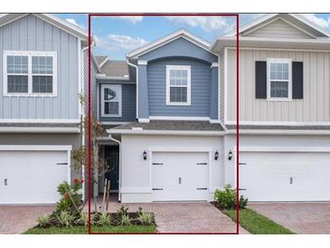 Charming two-story townhome featuring an attached garage, brick paved driveway, and manicured landscaping at 42858 Park View Dr, Punta Gorda, FL 33982