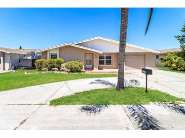 Charming single-story home featuring a well-maintained lawn, driveway, and attached garage at 7221 King Arthur Dr, Port Richey, FL 34668