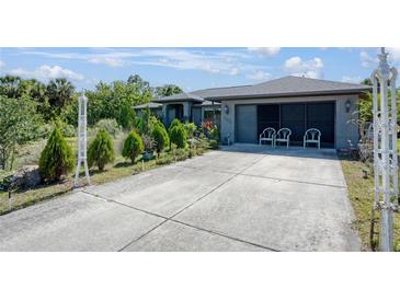 Charming single-story home with well-maintained landscaping, a spacious driveway, and attached two-car garage at 268 Cory St, Port Charlotte, FL 33953