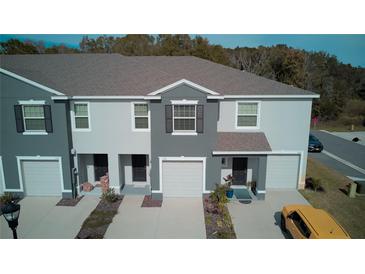 Modern townhouses with neutral exteriors, individual garages and manicured landscaping create curb appeal at 1570 Hubbell Rd, Wesley Chapel, FL 33543