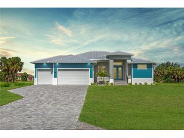 Beautiful home featuring a three-car garage, elegant gray brick driveway, and lush green lawn at 205 Rotonda S Blvd, Rotonda West, FL 33947