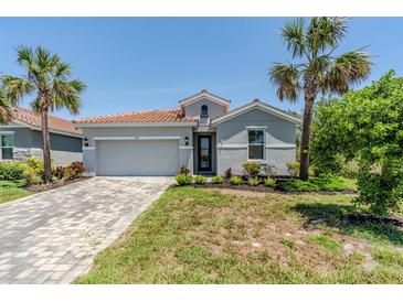 Charming single-story home with a red tile roof and tropical landscaping at 507 Daylily Blvd, Nokomis, FL 34275