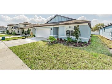 Charming single-Gathering home featuring a manicured lawn and attached two-car garage at 9661 Summers Cay Cir, Thonotosassa, FL 33592