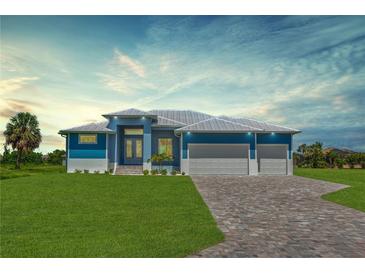 Beautiful blue single-story home featuring a well-manicured lawn and a three-car garage at 261 Rotonda S Blvd, Rotonda West, FL 33947