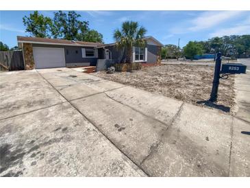 Charming single-story home featuring a gray exterior, well-maintained lawn, and a concrete driveway at 8253 Penwood Dr, Port Richey, FL 34668