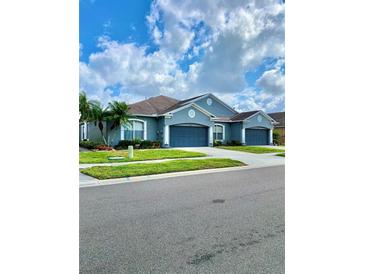 Beautiful exterior showcasing well-manicured lawn, two garages, and appealing curb appeal at 30442 Lettingwell Cir, Wesley Chapel, FL 33543
