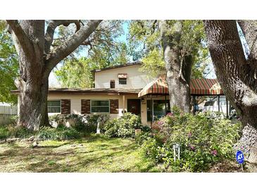 Charming two-story home with a well-manicured front yard and mature trees offering shade at 8641 May Cir, Tampa, FL 33614