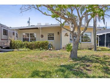 Charming single-story home featuring a well-maintained lawn and mature landscaping, creating a welcoming curb appeal at 15406 2Nd E St, Madeira Beach, FL 33708