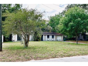 Ranch home featuring a covered entryway and a large front yard with mature trees offering plenty of shade at 4213 Temple Heights Rd, Tampa, FL 33617