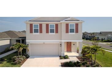 Charming two-story home with neutral siding, red shutters, a welcoming front door, and a well-maintained lawn at 6438 Milestone Loop, Palmetto, FL 34221