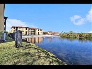 Scenic community view featuring a pond, fountain, and well-maintained buildings against a blue sky at 4333 Bayside Village Dr # 310, Tampa, FL 33615