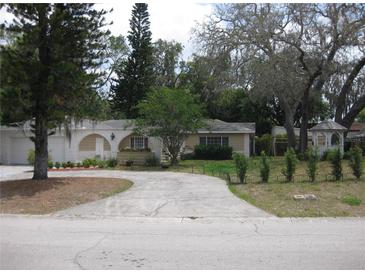 Charming single story home with a circular driveway, mature trees, and a detached gazebo at 7026 Lenape Cir, New Port Richey, FL 34653