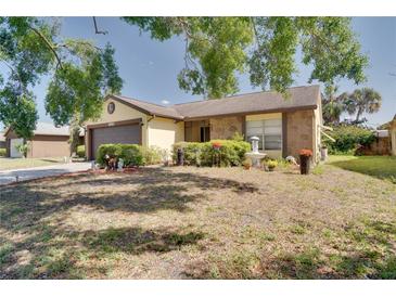 Charming home with a well-maintained front yard and mature landscaping, including a small fountain and decorative shrubbery at 7418 Riverbank Dr, New Port Richey, FL 34655