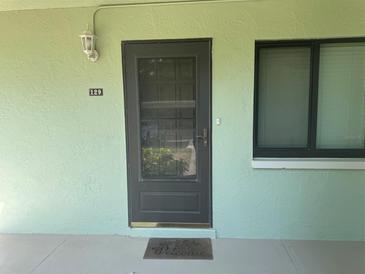 View of a front door with a 'welcome' mat and a window to the right at 129 Caryl Way # 129, Oldsmar, FL 34677