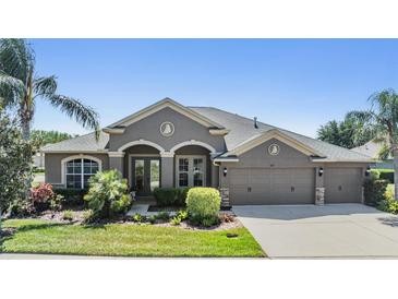 Charming one-story home boasts a well-manicured lawn, mature landscaping, and a three-car garage at 8721 Crystal Creek Ct, Land O Lakes, FL 34638