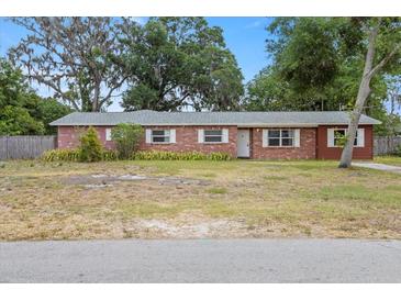 Charming single story brick home with white trim windows and spacious front yard at 408 Eunice Dr, Plant City, FL 33563