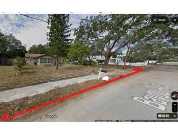 A view of the street and neighboring houses with mature trees and a paved sidewalk at 820 Bayou Ave, Tarpon Springs, FL 34689