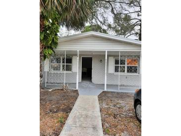 Charming single-story home featuring a welcoming front porch with decorative ironwork and an open entryway at 7240 Donna Dr, New Port Richey, FL 34652