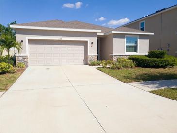 Charming single-story home with a two-car garage and a well-manicured lawn, perfect for families at 5144 Flowing Oar Rd, Wimauma, FL 33598