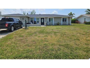 Charming single-story home featuring a well-maintained lawn and inviting front porch at 119 Caddy Rd, Rotonda West, FL 33947
