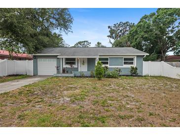 Charming single-story home with a blue exterior, well-maintained landscaping, and an attached garage at 2824 Oaklawn Ave, Largo, FL 33771