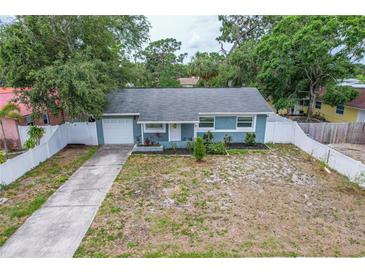 Charming single-story home features a blue exterior, well-maintained landscaping, and a white picket fence at 2824 Oaklawn Ave, Largo, FL 33771