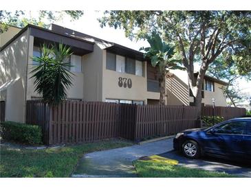 Charming condo with a brown fence, lush green lawn, and convenient parking at 870 Village Lake N Ter # 204, St Petersburg, FL 33716