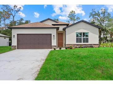 Inviting single-story home featuring a manicured lawn and a two-car garage at 2919 Cascabel Ter, North Port, FL 34286