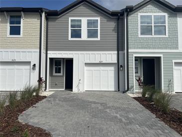 Charming townhomes featuring multi-tone exterior and modern paver driveway for inviting curb appeal at 7677 Deer Valley Circle, Tampa, FL 33635