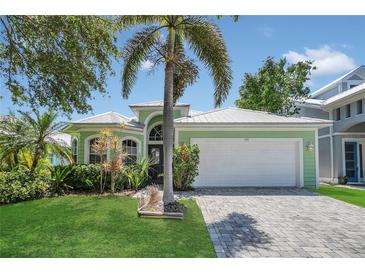 Charming, single-story home featuring lush landscaping, a palm tree, and a two-car garage at 530 Bimini Bay Blvd, Apollo Beach, FL 33572
