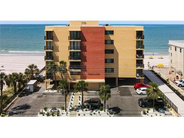 Beachfront condo building with balconies, parking, and palm trees, offering stunning ocean views and easy beach access at 14146 Gulf Blvd # 3A, Madeira Beach, FL 33708