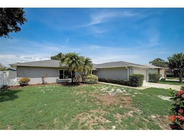 Charming single-story home featuring a well-maintained lawn and mature landscaping under a bright blue sky at 9497 122Nd Way, Seminole, FL 33772
