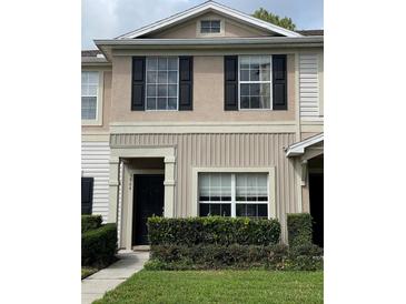 Charming townhome exterior with neutral paint, black shutters and tidy landscaping at 5864 Fishhawk Ridge Dr, Lithia, FL 33547