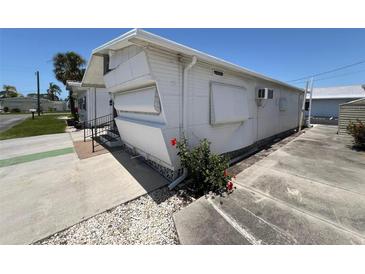 Exterior view of a mobile home with white siding and awnings, surrounded by well-maintained landscaping at 10315 Cortez W Rd # 18D, Bradenton, FL 34210