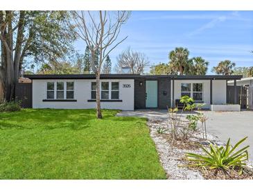 Charming single-story home with a well-maintained lawn, updated landscaping, and a light blue front door at 3926 Helena Ne St, St Petersburg, FL 33703