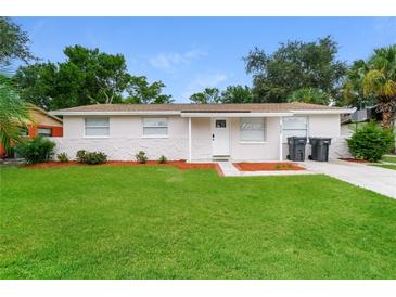 Charming single-story home featuring a well-manicured lawn, stone accents, and a classic white front door at 6426 Eden Ln, Tampa, FL 33634