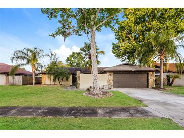 Charming single-story home with stone accents, mature trees, and a well-manicured lawn at 2006 Sycamore Ln, Plant City, FL 33563