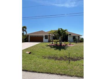 Charming single-story home features lush landscaping, a brown roof, and a two car garage at 8252 Tecumseh Cir, Port Charlotte, FL 33981