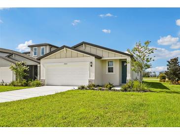 Charming single-story home features a manicured lawn and a two-car garage, complemented by blue skies at 14005 Crutchfield Ct, Parrish, FL 34219