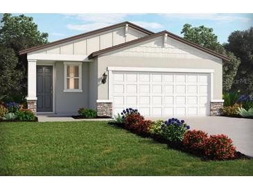 Charming single-story home with a gray exterior, white garage door, landscaped yard, and covered entryway at 14005 Crutchfield Ct, Parrish, FL 34219
