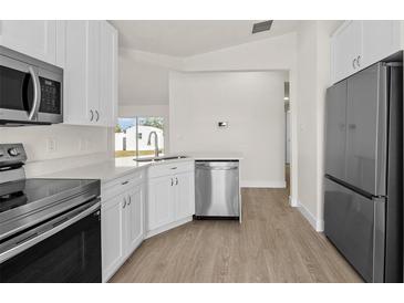 Bright kitchen features stainless steel appliances, white cabinets, and modern countertops, creating a clean and inviting space at 4604 Hunts Ave, Plant City, FL 33566