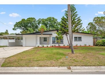 Charming single-story home featuring a lush green lawn and an attached carport at 5629 36Th N Ave, St Petersburg, FL 33710