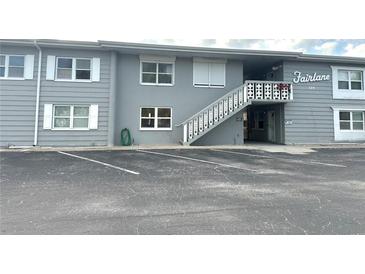 Two-story building featuring gray siding and a staircase leading to the upper-level entrances at 129 104Th Ave # 205, Treasure Island, FL 33706