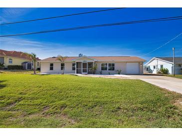 Charming single-story home with a well-maintained lawn and attached garage and screen front door at 1933 Oregon Trl, Englewood, FL 34224